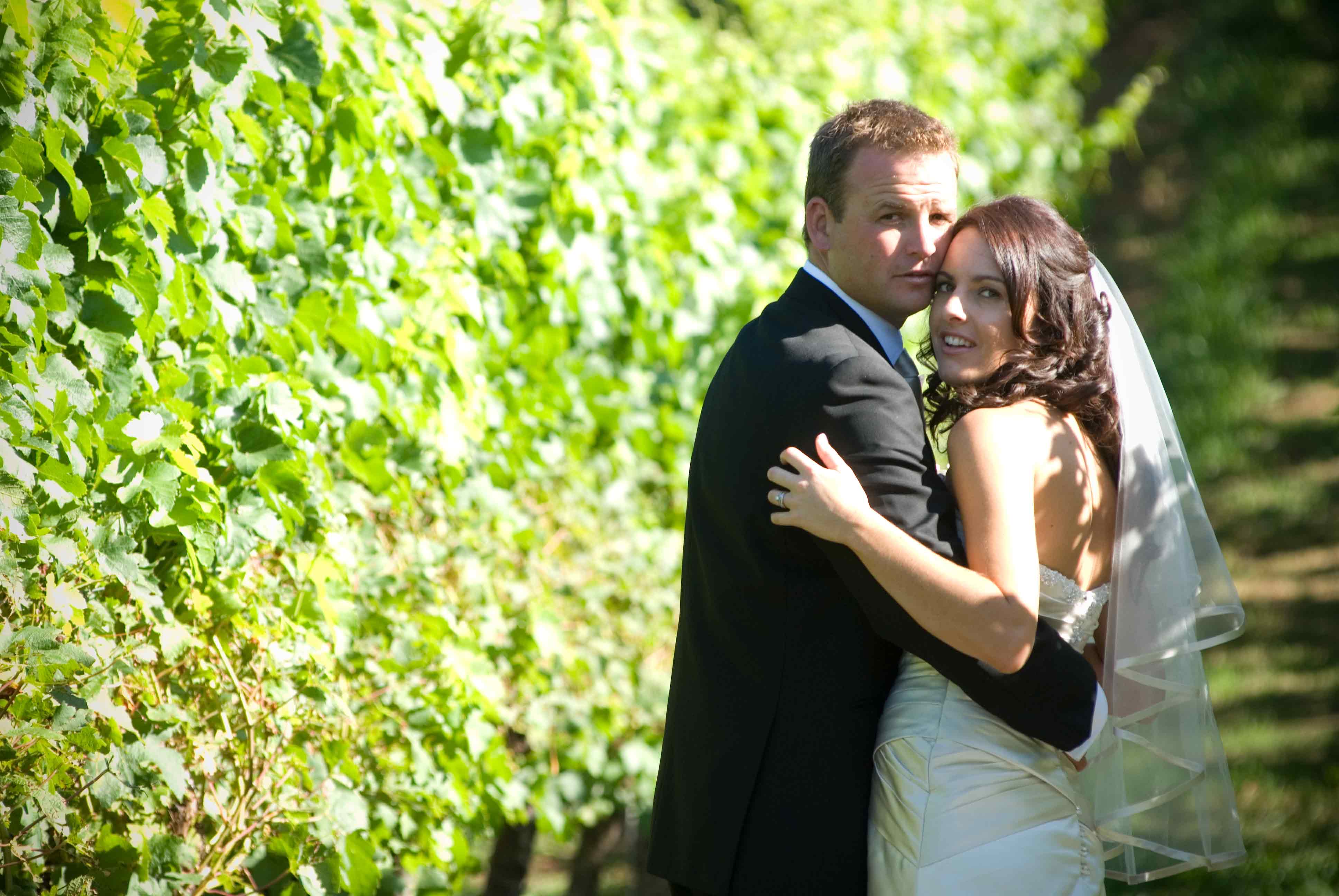 wedding-couple-looking-back-from-the-vines